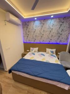 een slaapkamer met een groot bed met een blauw licht bij Skyline kaveri in Greater Noida