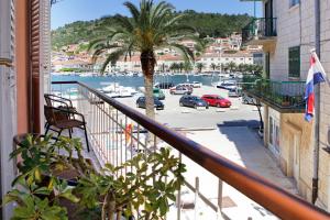 a balcony with a palm tree and a parking lot at B&B Vela Luka in Vela Luka