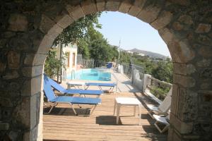 an archway with lounge chairs and a swimming pool at Hotel Eliza in Agios Nikolaos