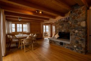 a living room with a stone fireplace and a table and chairs at Mountain Lodge Stummerberg in Stummerberg