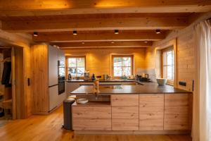 a large kitchen with wooden walls and wooden floors at Mountain Lodge Stummerberg in Stummerberg +15 photos
