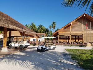 zwei Golfwagen vor einem Gebäude geparkt in der Unterkunft Shitha Inn in Hithadhoo
