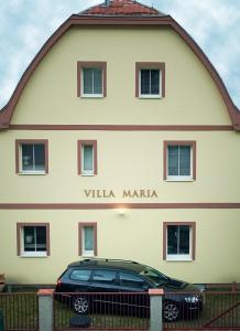 een zwarte auto geparkeerd voor een gebouw bij Pension Villa Maria in Karlsbad