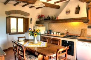 une cuisine avec une table en bois et un vase de fleurs. dans l'établissement Casa del Ponte, à Lucolena in Chianti