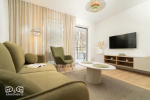 a living room with a couch and a tv at Apartament Zielony D&D APARTMENTS in Międzywodzie
