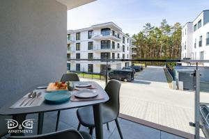 a table with a plate of food on a balcony at Apartament Zielony D&D APARTMENTS in Międzywodzie