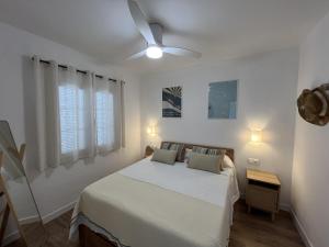 a bedroom with a bed and a ceiling fan at Castellsol 203 by SOM Menorca in Arenal d'en Castell +14 photos