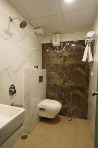 Un baño con inodoro, lavabo y ducha. en The Byke Landmark - Near C21 Mall, en Indore