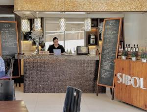 a woman sitting at a counter in a restaurant at The Intramuros Suite in Manila