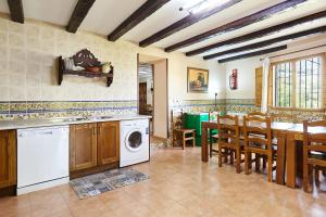 a kitchen with a washing machine and a dining room at Casa Rural Los Angostones in Villanueva del Arzobispo