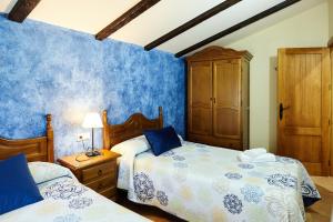 a bedroom with two beds and a wooden cabinet at Casa Rural Los Angostones in Villanueva del Arzobispo +27 photos