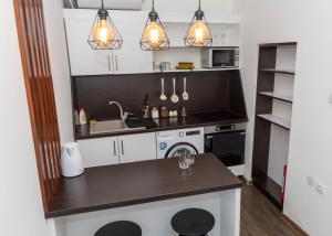 a kitchen with a sink and a stove at El Mundo Apartman in Bečej