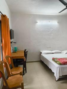 a bedroom with a bed and a desk and a chair at Sunleo Villas in Anachal