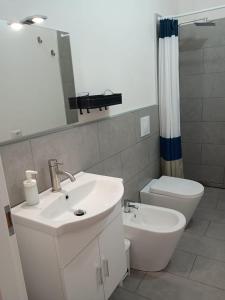 a bathroom with a sink and a toilet and a mirror at Mamè Guest House in Figlino