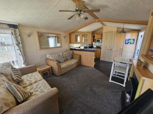 a living room with a couch and a kitchen at Meadow Lakes 56 in Chapel Saint Leonards