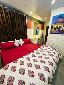 a bedroom with a red bed and a red couch at Travellers Village in Jaipur