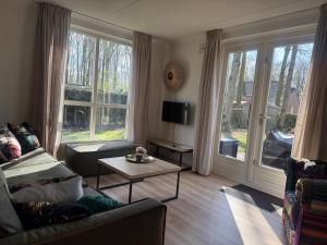 a living room with a couch and a table at Pure Wellness Bungalows 121 Sauna&Massage&Hottub in Ewijk
