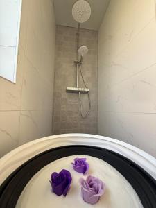 Una bañera con toallas moradas en un baño. en Pure Wellness with massage, en Ewijk 59 fotos más