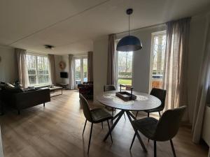 a living room with a table and chairs at Pure Wellness Bungalows 121 Sauna&Massage&Hottub in Ewijk