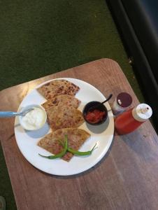 a white plate of food on a wooden table at Hotel Anushri Villa in Ahmedabad