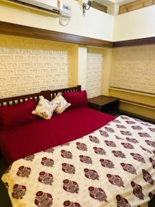 a bedroom with a red bed with roses on it at Travellers Village in Jaipur +163 photos