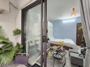 a small room with a bed and a glass door at Cygnus Homestay Ha Noi 89 in Hanoi