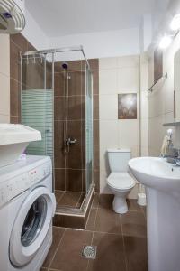 a bathroom with a washing machine and a toilet at Kefi apartment in Pefkohori