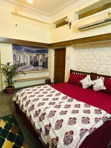 a bedroom with a large bed with a red blanket at Travellers Village in Jaipur