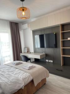 a bedroom with a bed and a desk and a television at Unirea Towers Deluxe Apartment Modern & Chic in Iaşi +27 photos