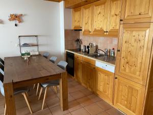 a kitchen with wooden cabinets and a wooden table at Charme assuré in Crans-Montana