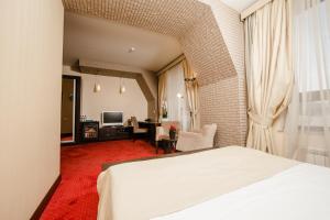 a hotel room with a bed and a living room at Passage Luxury Rooms Hotel in Baku