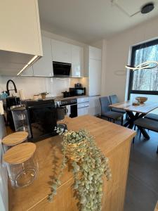 eine Küche mit einem Tisch mit einer Vase mit Blumen darauf in der Unterkunft ElbeCity Apartment in Dresden