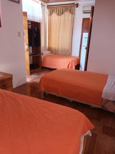 una camera d'albergo con due letti e uno specchio di Villa Galápagos a Huamboya