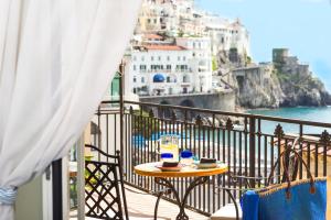 una mesa en un balcón con vistas al océano en Residenza Pansa B&B, en Amalfi