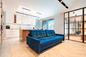 a living room with a blue couch in a kitchen at Comfort Apartments Grudziądzka in Gdańsk