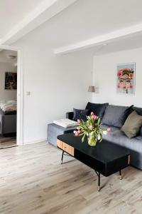 a living room with a couch and a table with flowers on it at Das Stader Schwedenhaus mit Garten in Stade