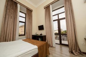 a bedroom with a bed and a large window at Passage Luxury Rooms Hotel in Baku