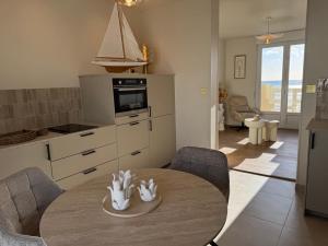 a kitchen with a table and chairs in a room at l'écrin de l'océan in Barneville-Carteret