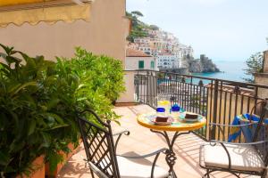 una mesa y sillas en un balcón con vistas al océano en Residenza Pansa B&B, en Amalfi