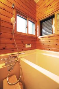 a bathroom with a bath tub with a shower at The Creek Cottage in Habu +88 photos