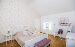 a white bedroom with a bed and a chair at Villa Blue by Villas Guide in Dubrovnik +28 photos