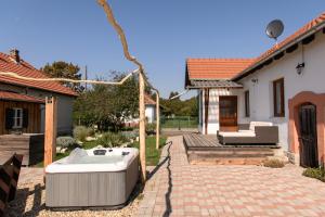 a hot tub in a yard next to a house at Tiszatardos Vendégházak in Tiszatardos