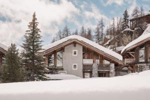 une maison dans la neige recouverte de neige dans l'établissement Chalet Mathilda - Les Chalets COVAREL, à Val dʼIsère
