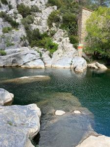 a body of water with rocks and a mountain at Élégant studio avec jacuzzi in Saint-Paul-de-Fenouillet +13 photos