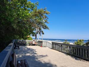 una persona sentada en un banco en la playa en ApartWest Słoneczna Dolina Jastrzębia Góra, en Jastrzębia Góra