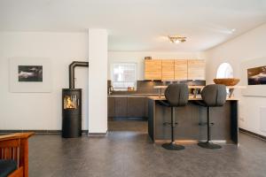 een keuken met een aanrecht en 2 krukken bij Ruhepol in Greetsiel