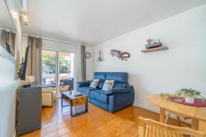 a living room with a blue couch and a table at Basic Comfort Apartment Pattaya 0158 in Empuriabrava