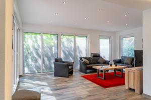 een woonkamer met meubilair en grote ramen bij Ruhepol in Greetsiel
