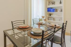 a dining room with a glass table and chairs at Le Foyer du Bizet in Lierna