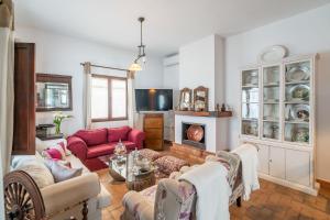 a living room with a red couch and a fireplace at Casa rural Pozo Viejo in Marchena